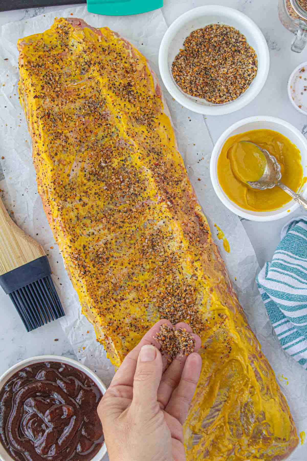 Montreal steak seasoning sprinkled over a rack of pork ribs to season them.