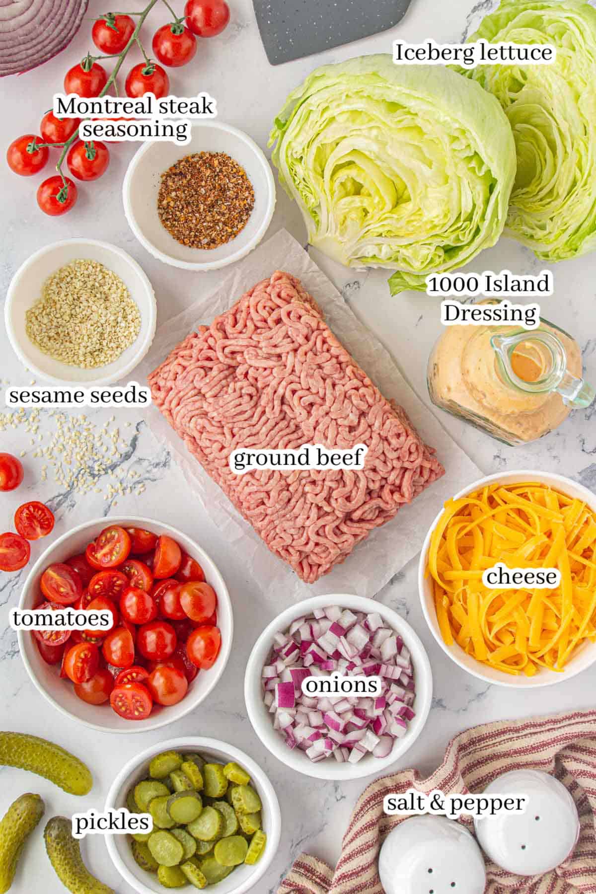 Ingredients for the salad including lettuce, tomatoes, onions, pickles, shredded cheese, salad dressing, sesame seeds and seasonings. With print overlay for clarification.