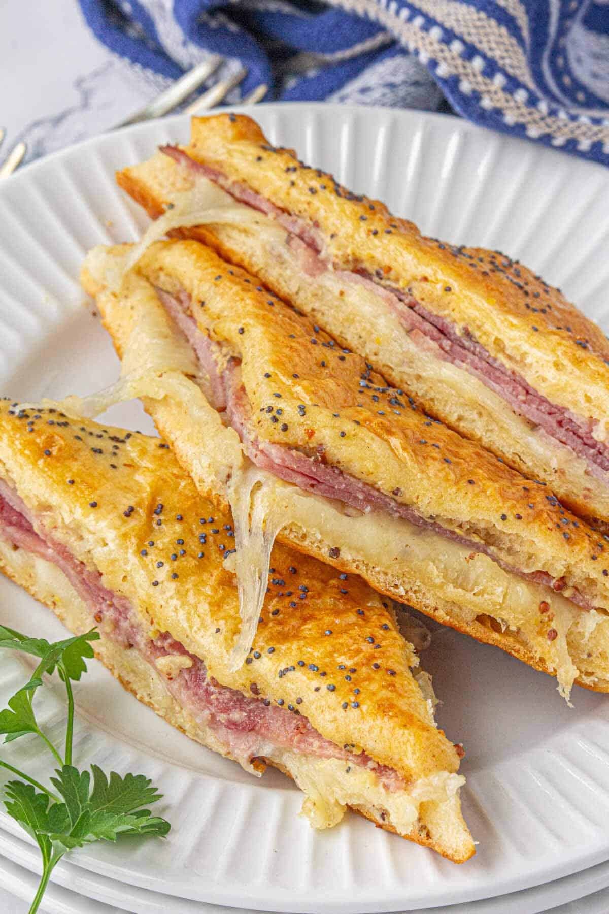 Three hot honey sandwiches on a plate.