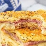 Croissant ham and cheese sandwich on a platter. Print overlay readers "Hot Honey Mustard Ham Sandwich, Easy Recipe! and Bowl-Me-Over.com