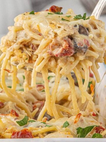 Cheesy Angel Chicken Casserole in baking dish, with a spatula removing a serving from the dish.