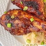 Overhead view of saucy baked bbq chicken drumsticks on a plate with creamy mashed potatoes, sprinkled with green onions, with text overlay "Baked BBQ Chicken Drumsticks".