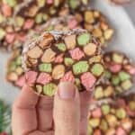 A hand holding a slice of Cathedral Window, with the remaining slices of candy in the background.
