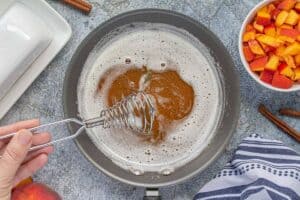 Browned butter bubbling in a skillet with a whisk.