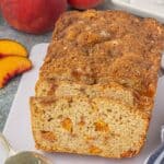 Overhead view of peach quick bread. It's been sliced revealing chunks of peaches.