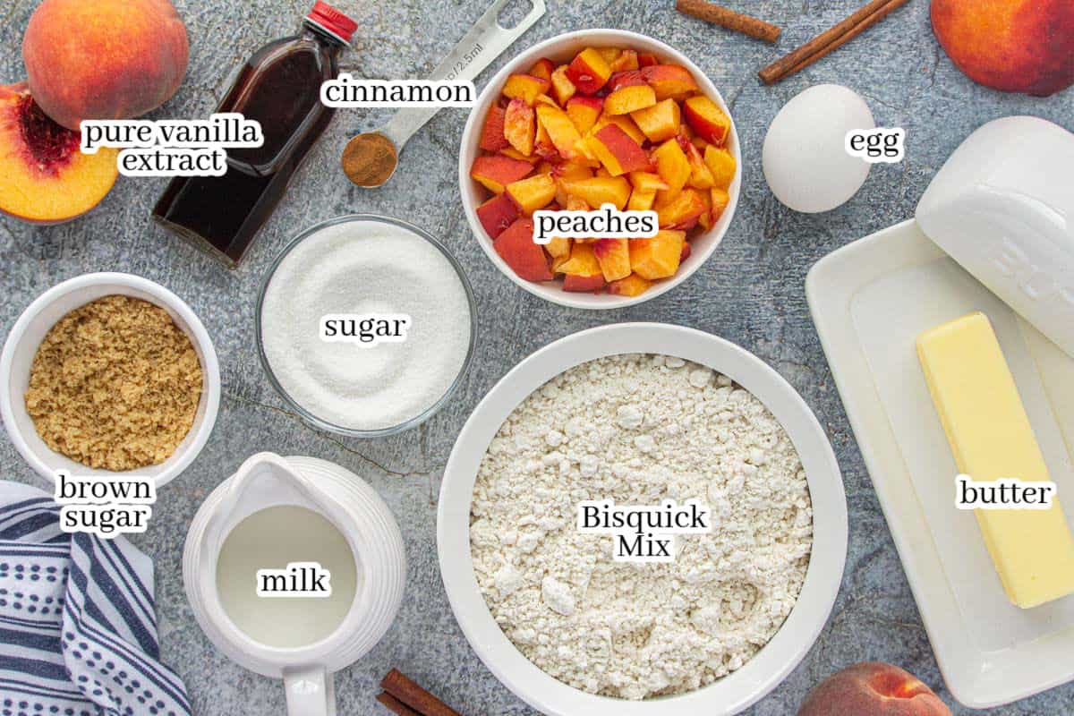 Overhead shot of Peach Quick Bread ingredients, including Bisquick, peaches, butter, egg, sugar, brown sugar, milk, vanilla, and cinnamon.