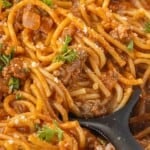 Close-up of spaghetti with tender noodles, seasoned ground beef, tomato sauce, and grated cheese.