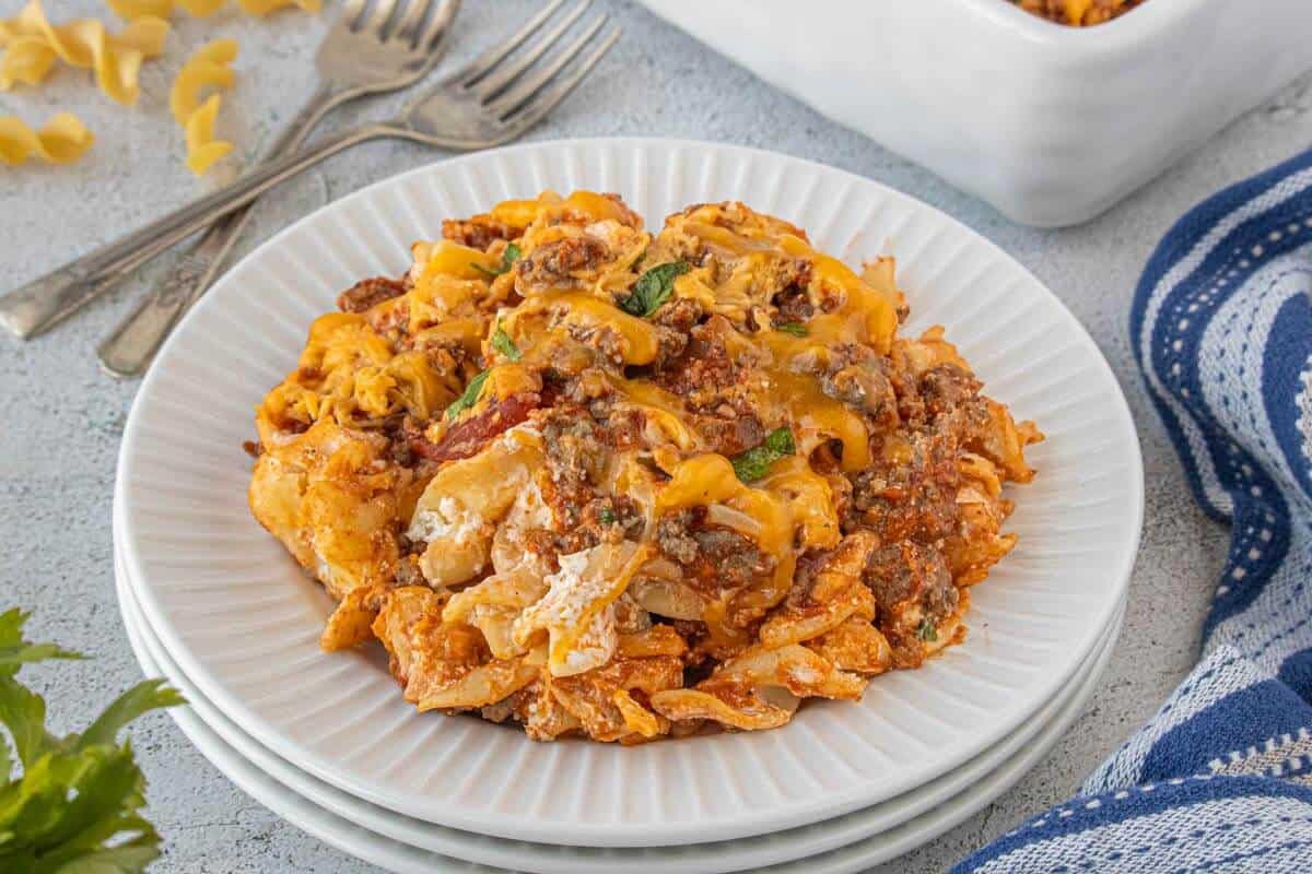 Single serving of poor mans casserole plated on a white dish with melted cheese and sauce.