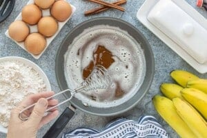 Butter browning in a saucepan with a whisk, surrounded by baking ingredients.