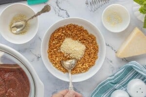 Toasted panko breadcrumbs in a small bowl with parmesan cheese, ready to mix together.