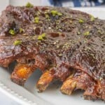 Close-up of juicy barbecue ribs with thick, glossy sauce and caramelized edges.