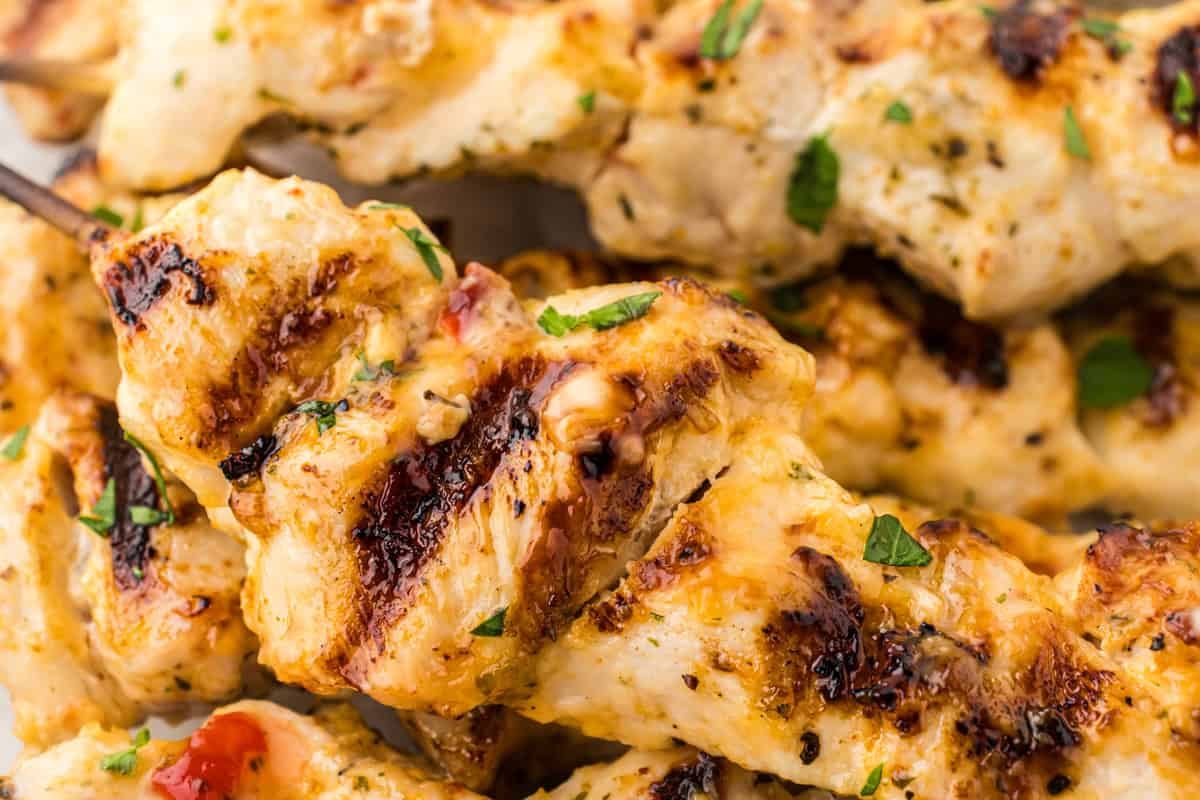 Close up view of bang bang chicken skewers on a platter.