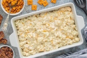 Creamy cauliflower casserole mixture spread into a white baking dish.