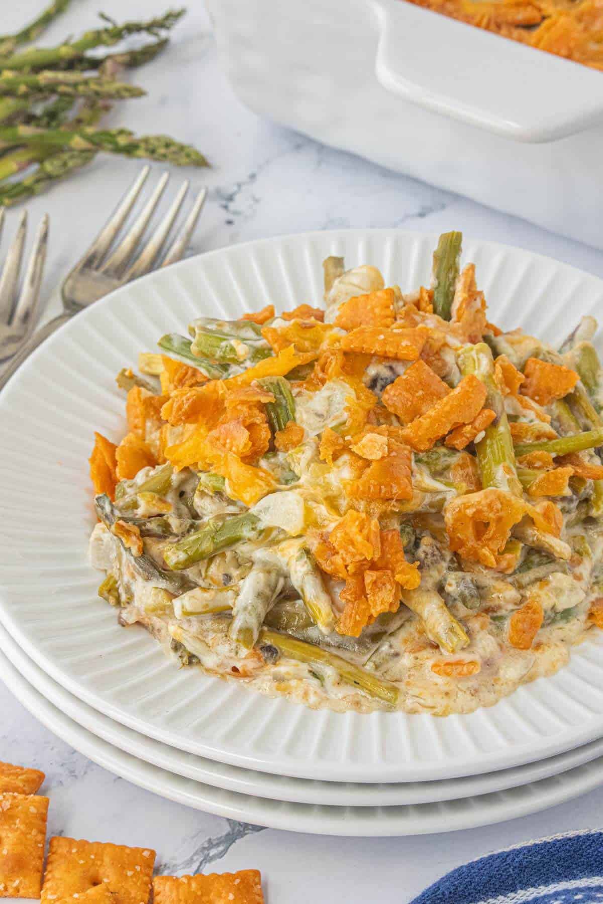 A serving of cheesy asparagus casserole on plate, ready to eat.