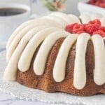 Close-up of White Chocolate Raspberry Bundt Cake with raspberry ribbons and a creamy frosting topping.