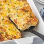 Close-up of a slice of Leftover Pizza Casserole being served from a casserole dish.
