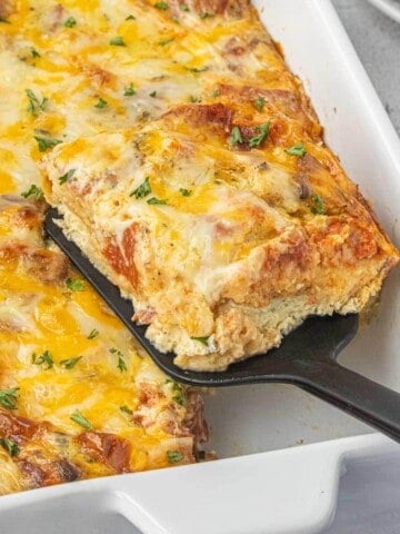 Close-up of a slice of Leftover Pizza Casserole being served from a casserole dish.