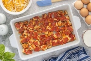 Chopped leftover pepperoni pizza arranged in the bottom of a baking dish.