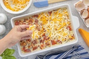 Sprinkling shredded cheese over chopped leftover pizza and egg mixture before baking the casserole.