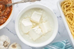 Cottage cheese and cream cheese in a bowl prepared for the creamy layer of spaghetti pie casserole.