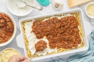 Savory meat sauce spooned over the creamy cheese layer in an unbaked spaghetti pie casserole.