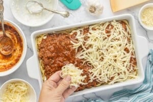 Shredded mozzarella cheese sprinkled over meat sauce before baking spaghetti pie casserole.