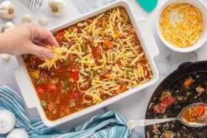 Sprinkling shredded cheese over the casserole before baking.