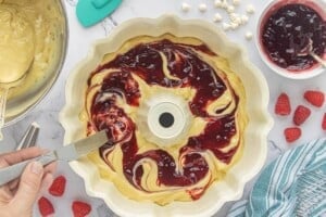 Swirling raspberry preserves into cake batter before baking.