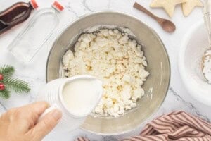 Pouring milk into the butter and powdered sugar mixture.