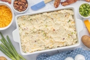 Creamy potato mixture spread evenly into a 9x13-inch baking dish.