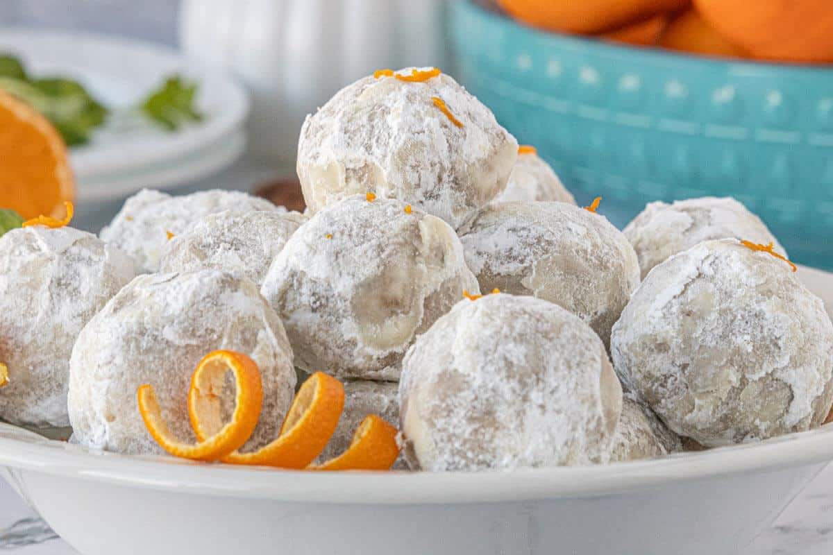 Orange Snowballs with a sweet powdered sugar coating and fresh orange zest piled in a serving bowl for a festive no-bake dessert.