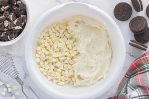 White chocolate chips and cream cheese frosting in a mixing bowl before melting.