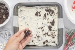Oreo fudge spread into a parchment-lined 8x8-inch pan and topped with extra chopped Oreo cookies before chilling.