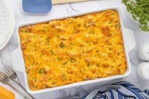 Baked casserole topped with melted cheddar cheese fresh from the oven, baked until golden brown and sprinkled with parsley.