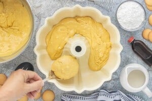 Thick Vbatter is spooned into a greased Bundt pan before baking.