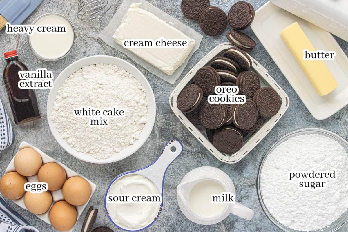Oreo Bundt Cake ingredients including white cake mix, Oreo cookies, eggs, sour cream, milk, butter, cream cheese, heavy cream, vanilla, and powdered sugar.