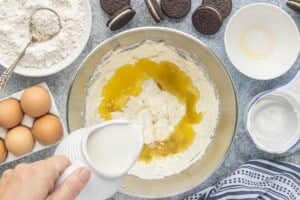 Melted butter and milk being added to the cake batter.