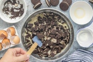 Chopped Oreo cookies being folded into the cake batter.