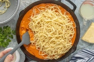 Cooked pasta added to the skillet with shrimp and creamy tomato sauce.