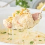 Close-up of tender chicken and ham in creamy sauce with melted cheese and crushed Ritz cracker topping.