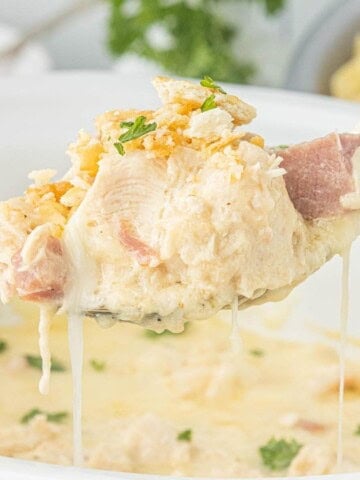 Close-up of tender chicken and ham in creamy sauce with melted cheese and crushed Ritz cracker topping.