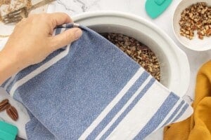 Covering the slow cooker with a kitchen towel before placing the lid on top.