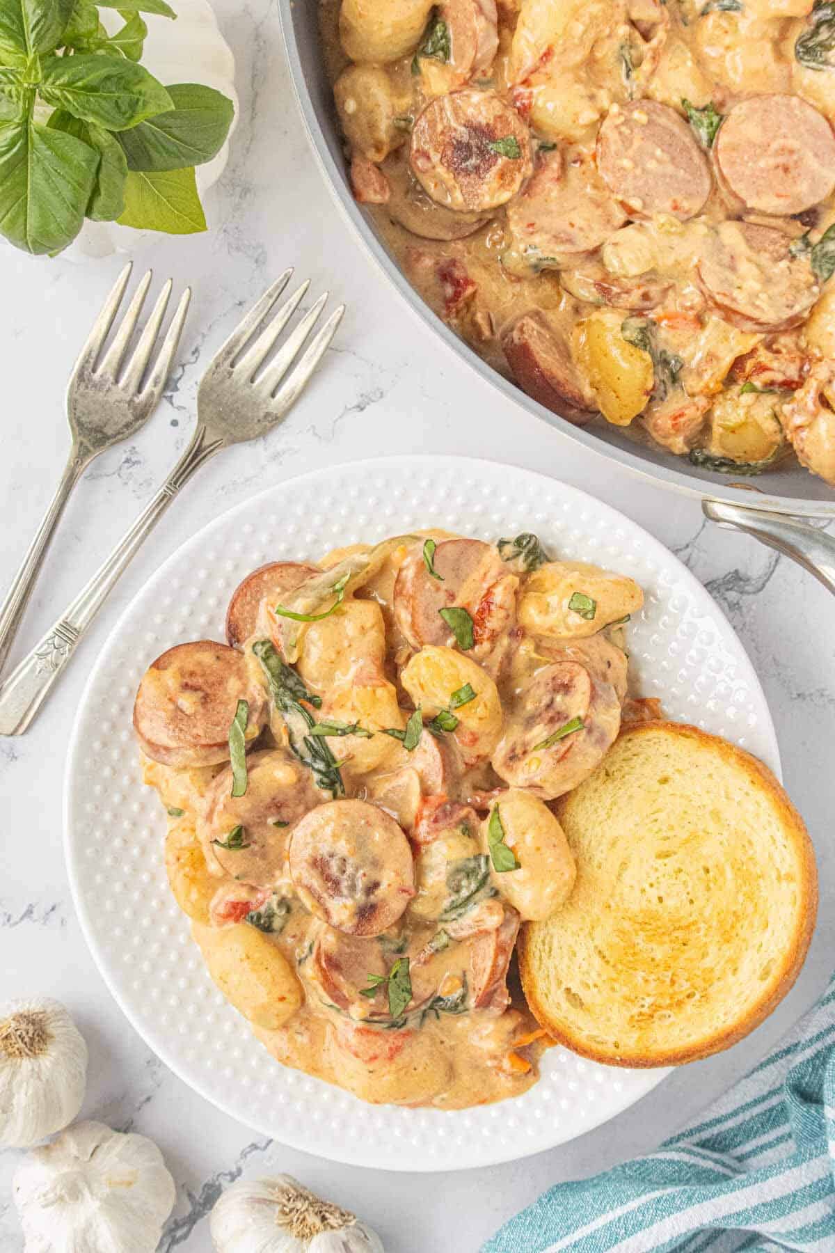 Creamy chicken sausage and potato gnocchi with spinach and sun-dried tomatoes served with toasted bread.
