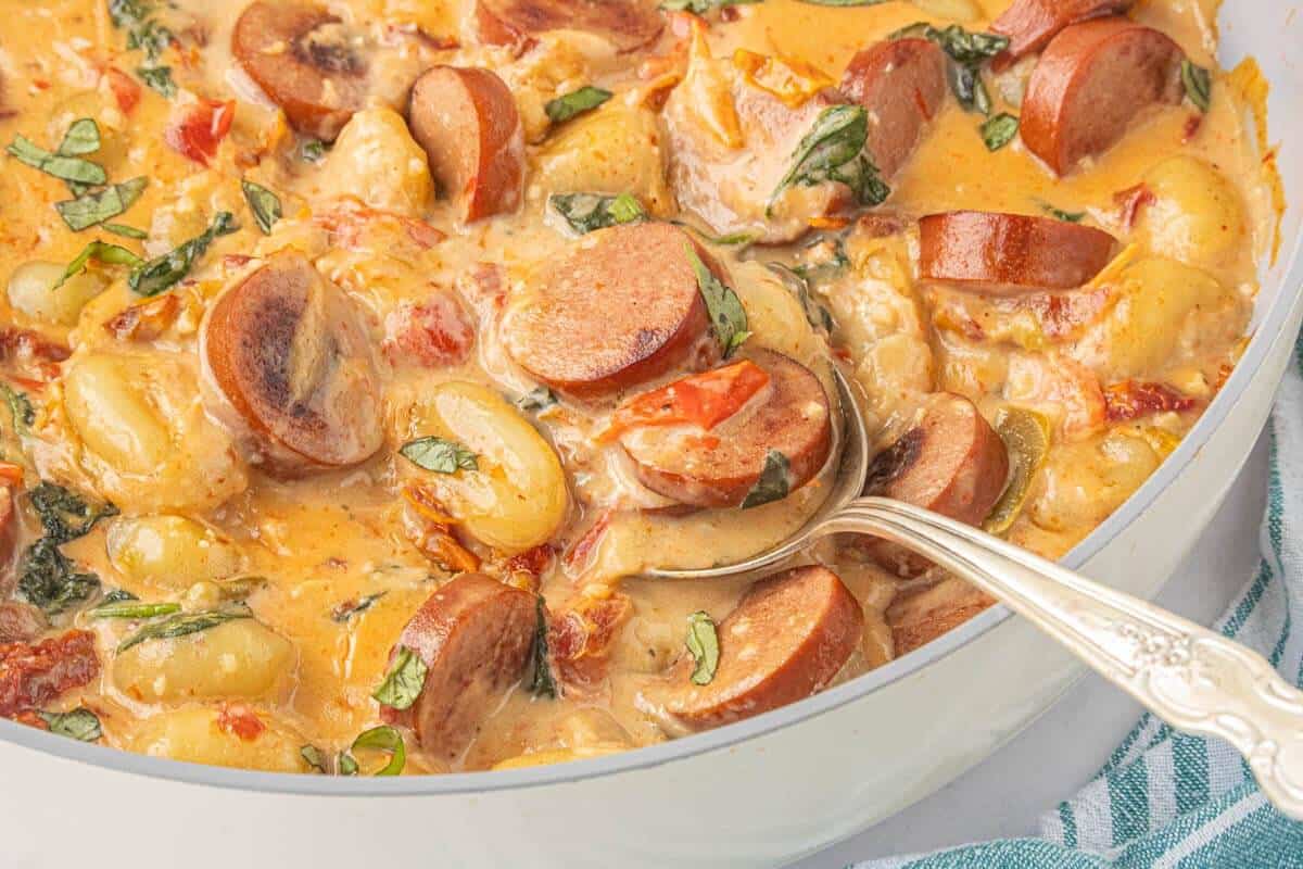 Creamy chicken sausage skillet with potato gnocchi, spinach and sun-dried tomatoes in Parmesan sauce.
