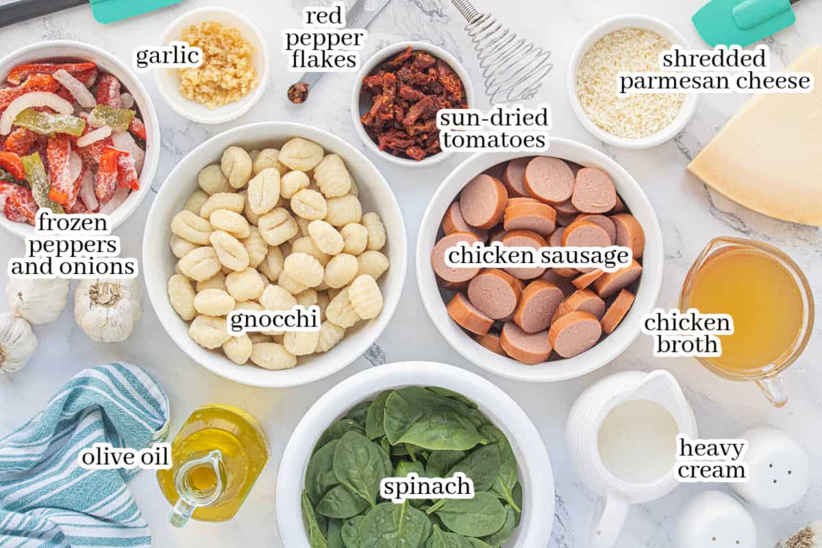 Ingredients for creamy chicken sausage dinner including potato gnocchi, spinach, sun-dried tomatoes, peppers, onions, Parmesan, cream and chicken broth.