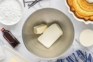 Softened cream cheese and butter in a mixing bowl for making the frosting.
