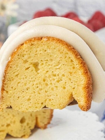Close-up of a vanilla Bundt cake slice showing the soft crumb and thick cream cheese frosting.