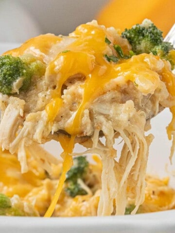 Spoonful of Crockpot Chicken and Rice with Broccoli with shredded chicken, creamy rice, broccoli, and melted cheddar cheese.